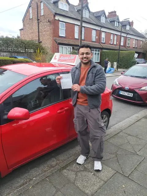 A Learners' Club pupil holding their driving test pass certificate