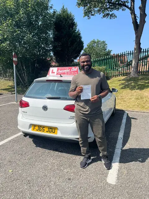 A Learners' Club pupil holding their driving test pass certificate