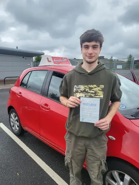 A Learners' Club pupil holding their driving test pass certificate